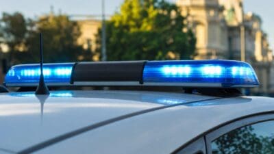 Aktiviertes blaues Blaulicht auf dem Dach eines weißen Polizeifahrzeugs