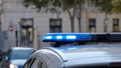 Nahaufnahme des blauen Blinklichts auf dem Dach eines Polizeiautos mit unscharfem Hintergrund