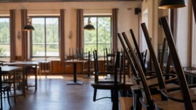 Leerer Gastraum des Sternbräu mit dunklen Holzstühlen und Tischen vor großen Fenstern