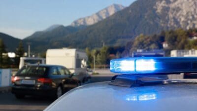 Leuchtendes blaues Blaulicht einer Einsatzleuchte im Vordergrund mit Bergen im Hintergrund