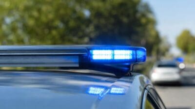 Nahaufnahme eines aktivierten blauen Blinklichts auf einem Polizeifahrzeug
