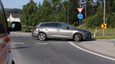 Beschädigter grauer Kombi steht schräg im Kreisverkehr auf der L518 in Spielberg.