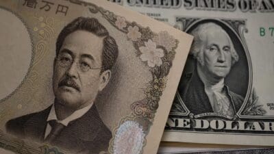Ein japanischer 10.000-Yen-Schein liegt über einem US-Dollar-Schein mit Porträts.