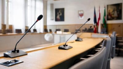 Leerer Sitzungssaal des Wattener Gemeinderats mit langem Holztisch und Mikrofonen