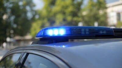 Das leuchtende blaue Blaulicht eines Polizeifahrzeugs ist in einer Nahaufnahme zu erkennen.