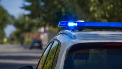 Nahaufnahme des blauen Blaulichts auf dem Dach eines Polizeifahrzeugs vor unscharfem Hintergrund