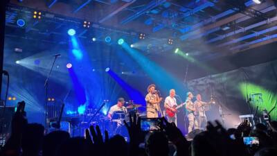 Die Fäaschtbänkler spielen unter blauem Bühnenlicht vor dem Publikum in der Messehalle Klagenfurt.