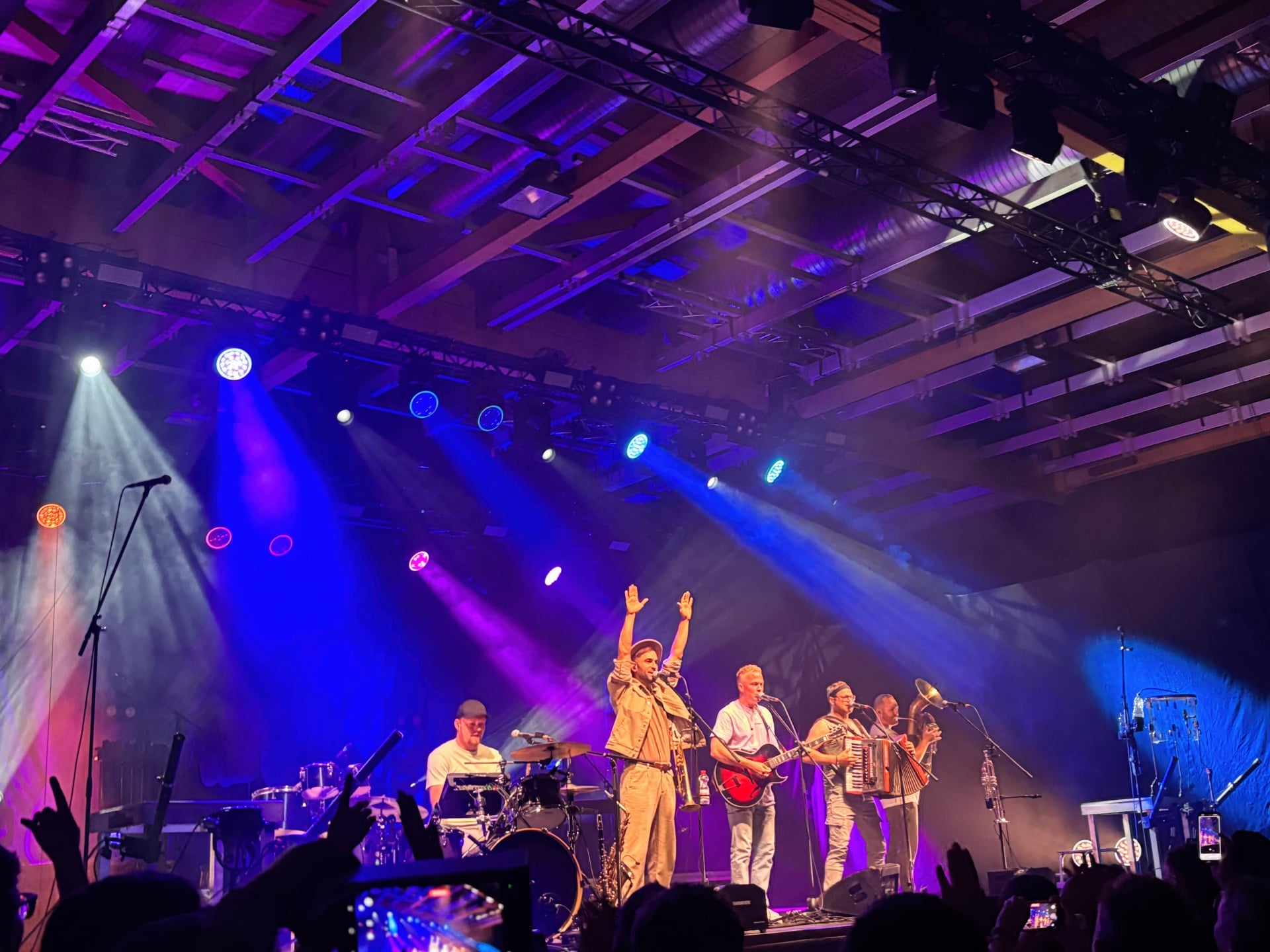 Die Fäaschtbänkler spielen unter farbigem Bühnenlicht in Klagenfurt.