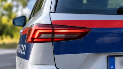 Nahaufnahme des Hecks eines österreichischen Polizeiautos mit rot-blauer Kennzeichnung.