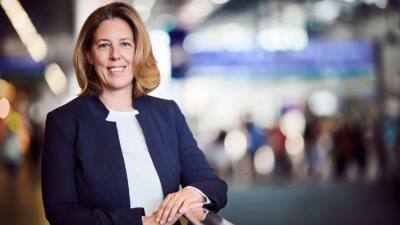 Christine Stockhammer-Kostelka lächelt in die Kamera und lehnt mit den Händen an einem Geländer.