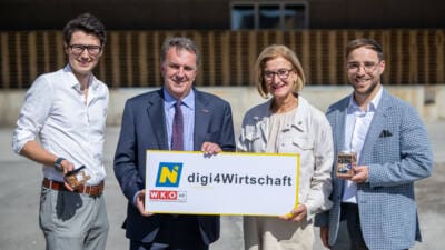 Vier Personen präsentieren ein Schild zur Förderinitiative digi4wirtschaft in Niederösterreich.