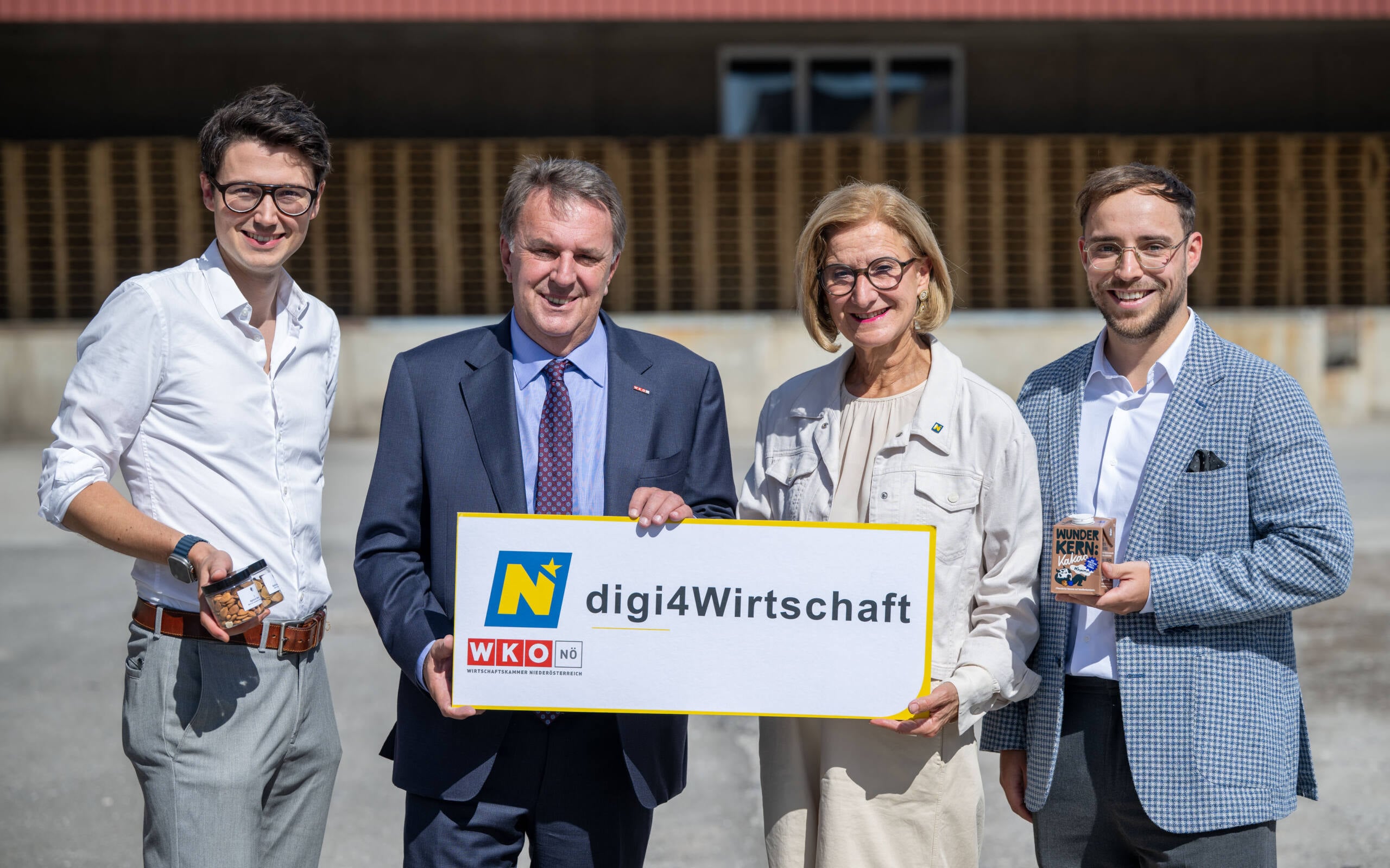 Vier Personen präsentieren ein Schild zur Förderinitiative digi4wirtschaft in Niederösterreich.