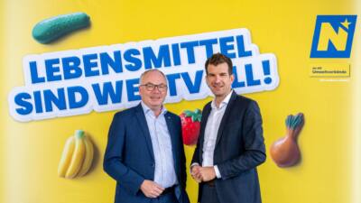 Stephan Pernkopf und Christian Macho vor einer gelben Lebensmittelkampagnenwand