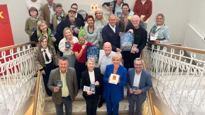 Gruppe von Menschen auf einer Treppe hält Broschüren mit der Aufschrift Museen in den Händen.