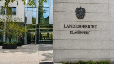 Fassade des Landesgerichts Klagenfurt mit Wappen und Inschrift auf Betonwand