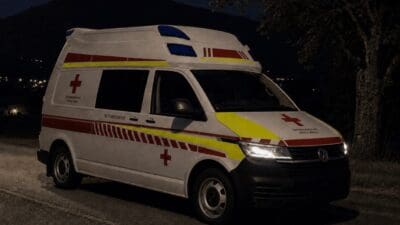 Weißer Rettungswagen des Österreichischen Roten Kreuzes bei Nacht mit Blaulicht auf der Straße