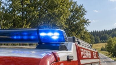 Österreichisches Feuerwehrauto mit blauem Blaulicht auf einer Landstraße