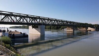 Grüne Stahlbrücke über der Donau mit Bauarbeiten an den Strompfeilern in Mauthausen