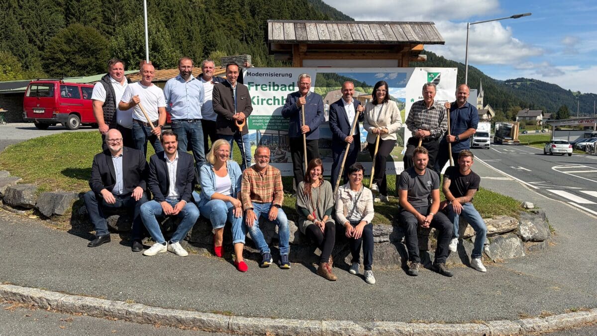 Gruppe von Personen mit Spaten vor dem Schild zur Modernisierung des Freibads Kirchbach