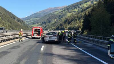 Feuerwehrleute sichern den Unfallort eines Pkw auf der Autobahn.
