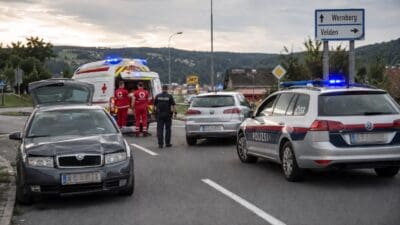 Beschädigtes Auto und Polizeifahrzeug mit Blaulicht neben Rettungswagen an Unfallstelle bei Wernberg