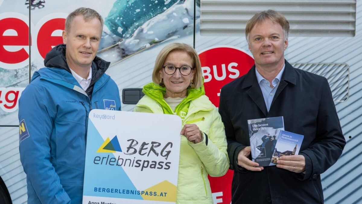 Markus Redl, Johanna Mikl-Leitner und Michael Duscher präsentieren den Bergerlebnispass vor einem Bus.