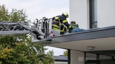 Drehleiter rettet verletzte Person von einem Vordach