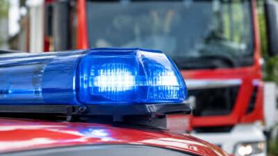 Blaues Warnlicht auf rotem Einsatzfahrzeug, dahinter ein Feuerwehrfahrzeug