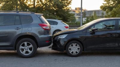 Grauer SUV und schwarzer Pkw mit schwer beschädigter Front nach einem Zusammenstoß