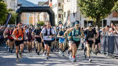 Ultraläufer mit Startnummern und Trinkwesten laufen durch die Schwazer Altstadt.