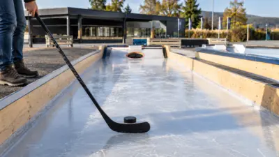 Person mit Eishockeyschläger und Puck auf einer Eisbahn