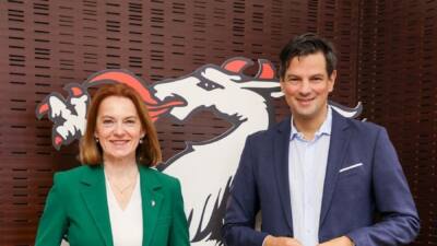 Eine Frau und ein Mann stehen vor einer großen weißen Pantherfigur.