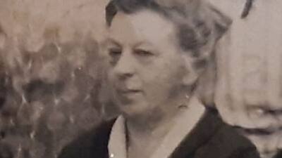 Ein monochromes Porträt zeigt eine Frau in dunkler Kleidung.