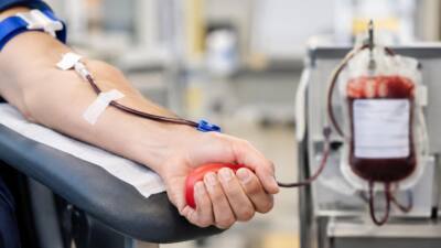 KI-Symbolbild: Ein Arm mit Schlauch neben einem Blutbeutel, eine Hand hält einen roten Ball.