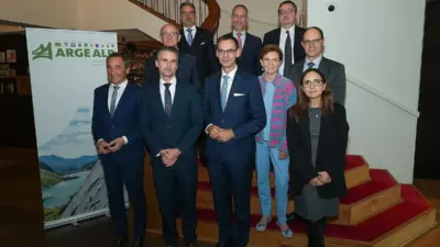Eine Gruppe steht für ein Foto neben einem ARGE-ALP-Aufsteller; die ARGE-ALP-Konferenz fand in Bregenz statt.