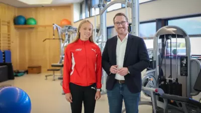 Leichtathletin Deborah Achleitner steht mit Sportreferent Philip Wohlgemuth in einem Trainingsraum.