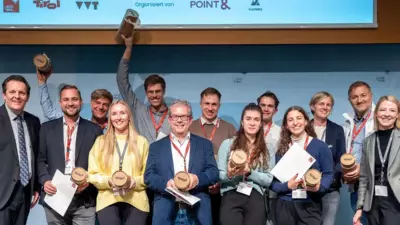 Teilnehmende zeigen bei der Präsentation von Ideen zur Tourismusmobilität in Innsbruck Urkunden und Auszeichnungen.