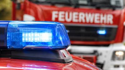 Blaues Blinklicht auf einem roten Einsatzfahrzeug, dahinter ein unscharfes Feuerwehrfahrzeug.