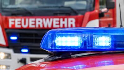 Blaues Einsatzlicht im Vordergrund, dahinter ein unscharfes Feuerwehrfahrzeug