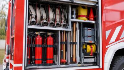 Geöffneter Geräteraum eines Feuerwehrfahrzeugs mit Schläuchen und weiterer Ausrüstung