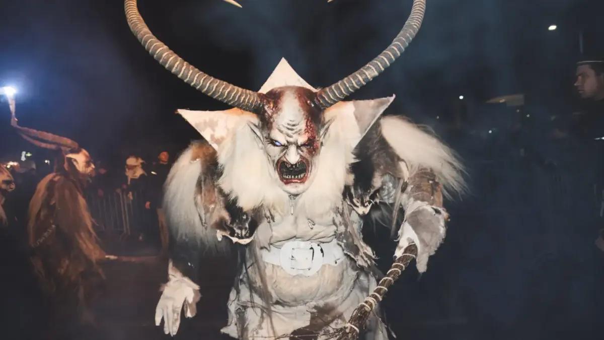 Eine Krampusfigur mit langen Hörnern und Fellkostüm bei einem nächtlichen Krampuslauf